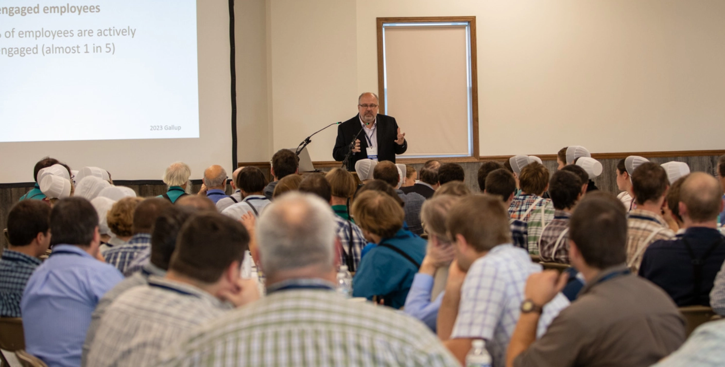 Leon Yoder speaking to an engaged audience at a business workshop